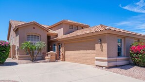 A two-story house with a garage, a driveway, and a well-maintained lawn. - Rare 3 FULL bathroom home in golf community W/ private pool. Experienced Host. (Mesa)