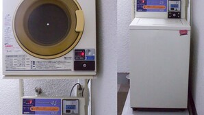 Een wasserette met twee wasmachines, elk met een digitaal display en bedieningspaneel.