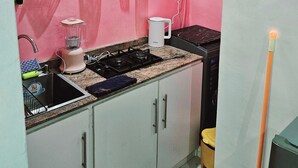 A kitchen with a sink, stove, and a white cabinet above the counter. - Motalvin Court  (Lagos)