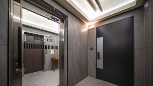 An elevator interior with a modern design, featuring a metallic door and a control panel.