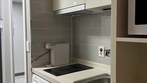 A compact kitchen with a built-in washer, a microwave, and a sink. - HoyaStay (Yeosu)