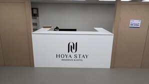 A reception desk with a sign reading "HOYA STAY RESIDENCE & HOTEL". - HoyaStay (Yeosu)