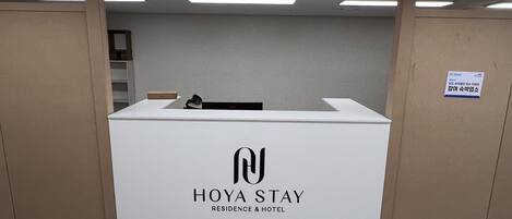 Una recepción con un letrero que dice 'HOYA STAY RESIDENCE & HOTEL'.