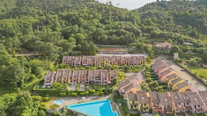 A residential area with multiple apartment buildings, a swimming pool, and a tennis court. - Villaggio 5 Terre by Interhome (Pignone)