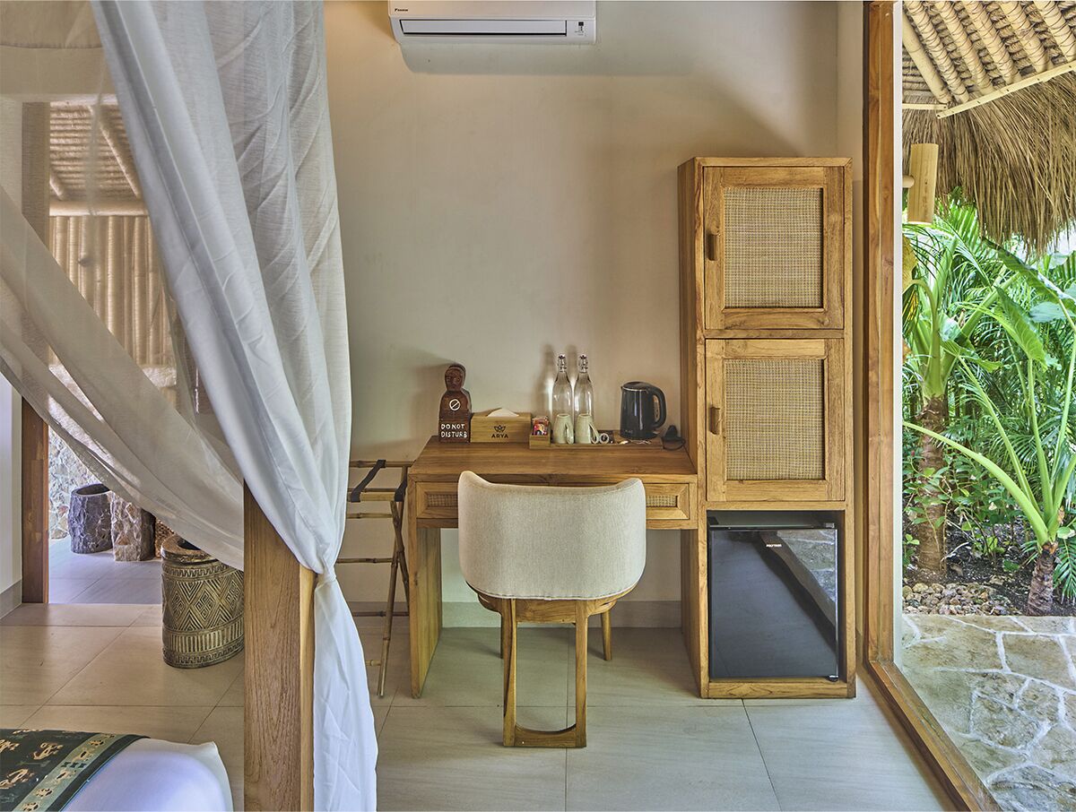Una habitación con cama, escritorio, silla, armario y vistas a zonas verdes.