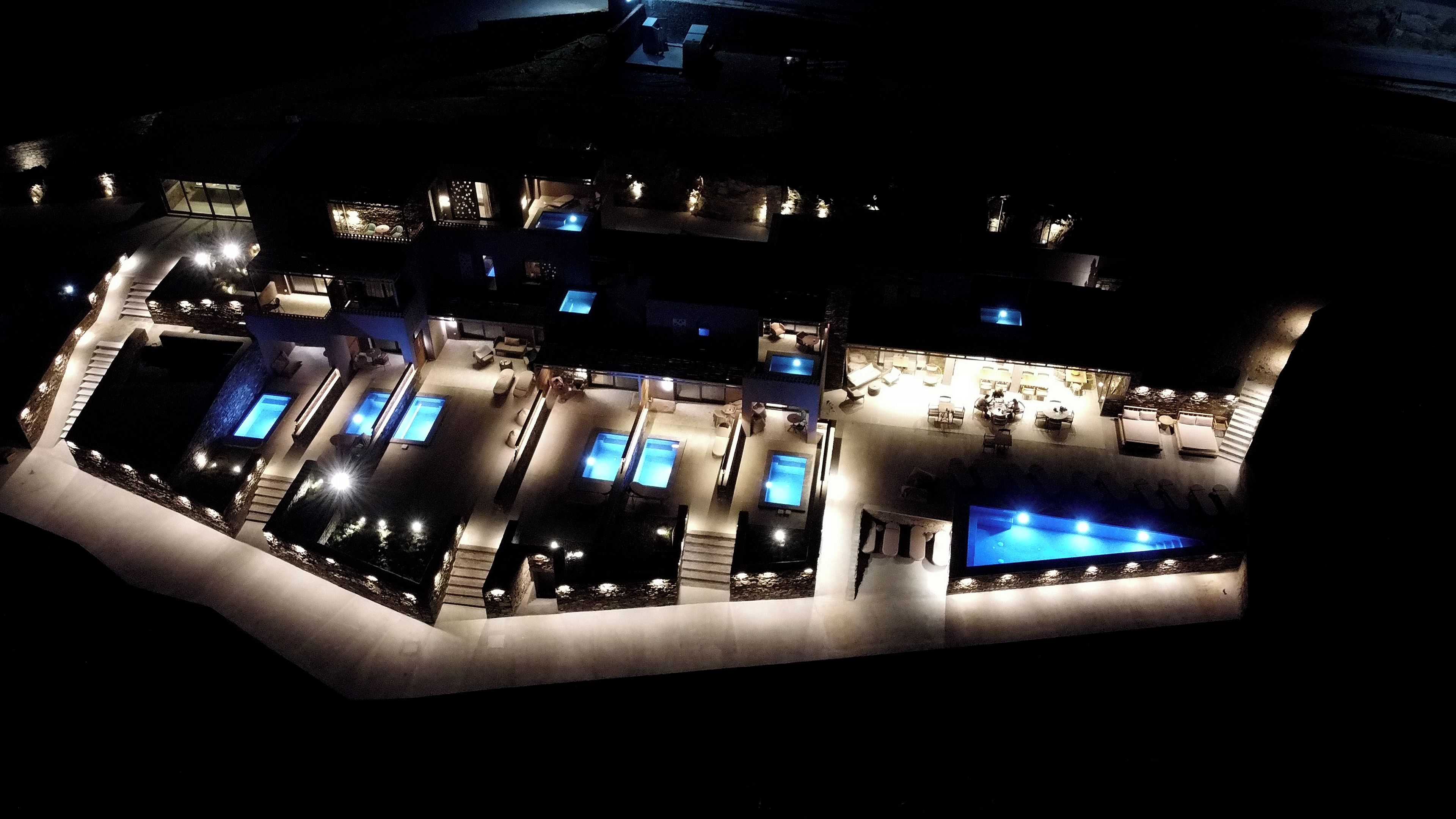 Vue aérienne d’un complexe hôtelier doté de plusieurs piscines, d’espaces de détente en plein air et d’une grande piscine centrale.