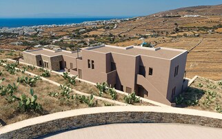 Un edificio moderno con techo plano y un muro de contención de piedra.