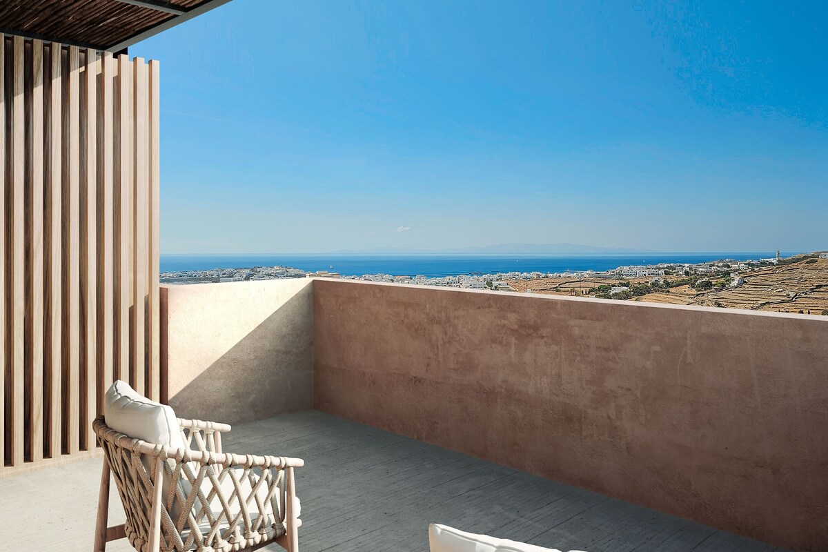 A balcony with wicker furniture and a view of the sea.
