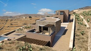 Una villa moderna con fachada de piedra, piscina en la azotea y vistas del paisaje circundante.