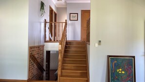 A wooden staircase with a handrail and a picture frame on the wall.