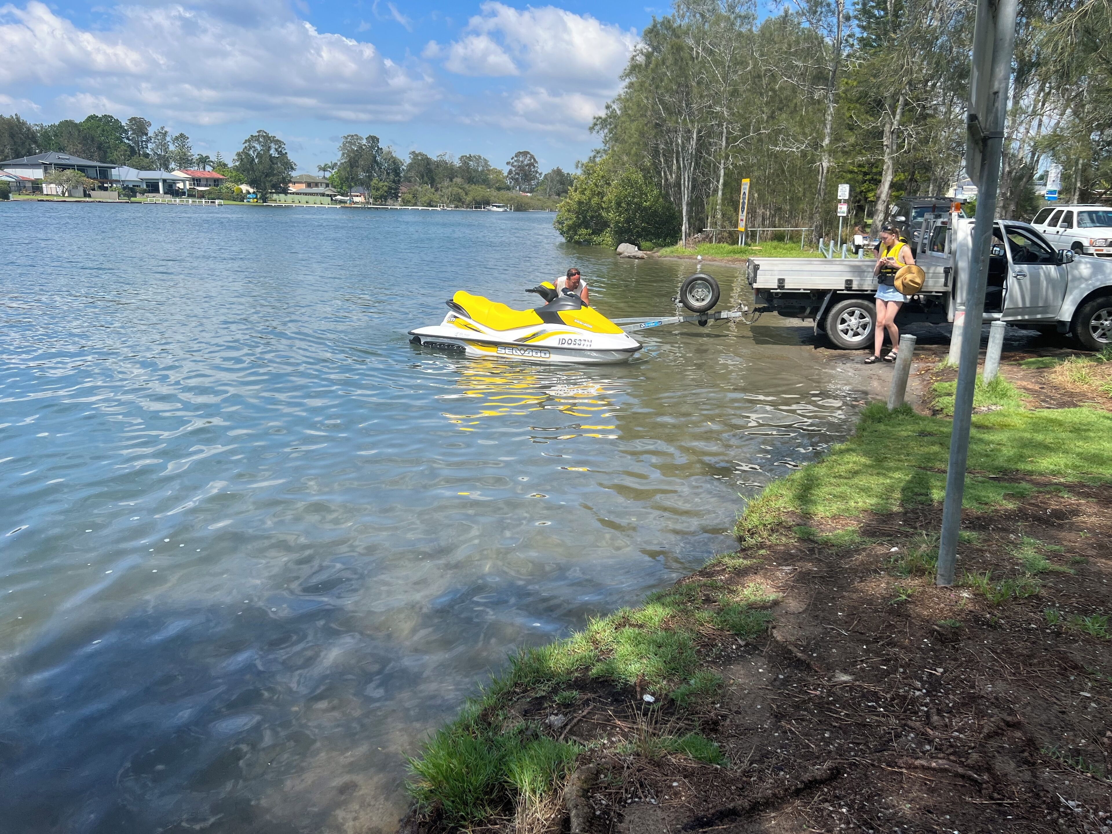 Un lac avec un jet ski et un camion sur la rive.