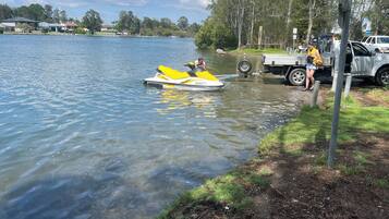 Un lac avec un jet ski et un camion sur la rive.