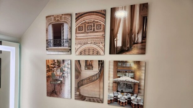 Eine Wand mit sechs gerahmten Bildern, die architektonische Details und Innenräume zeigen.