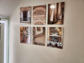 Eine Wand mit sechs gerahmten Bildern, die architektonische Details und Innenräume zeigen.