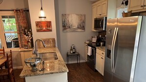 Una cucina moderna con ripiani in granito, elettrodomestici in acciaio inossidabile e un'isola centrale.
