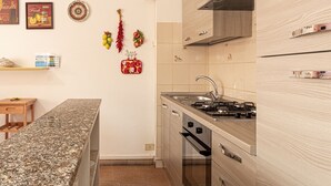 Una cocina moderna con encimera de granito, electrodomésticos de acero inoxidable y armarios de madera.