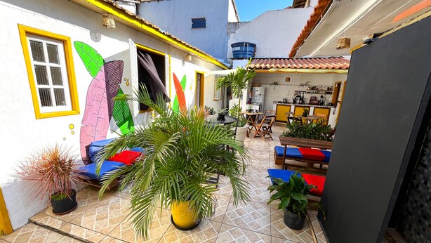 Une cour avec un sol carrelé, des sièges extérieurs et des plantes en pot.