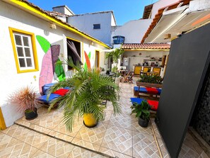 Un patio con suelo de baldosas, asientos al aire libre y plantas en macetas.