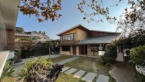 Une maison moderne à deux étages, avec un chemin de pierre menant à l’entrée.