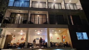 Un hôtel à plusieurs étages doté de balcons, d’un espace de réception et d’une salle à manger.