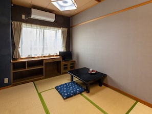 A room with tatami flooring, a television on a wooden stand, a small table with a cup and saucer, and a window with curtains. - Tabist Oyado Chitose (Kazuno)