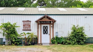 A building with a sign indicating it is a campground with guest facilities. - RV Site #12 Ouachita Campground at Edendell (Oden)