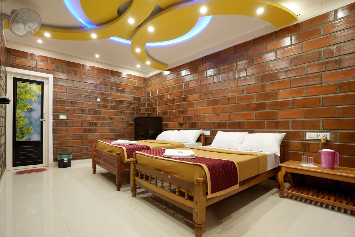 Une pièce avec deux lits en bois, un mur en briques et un plafond orné de luminaires circulaires.