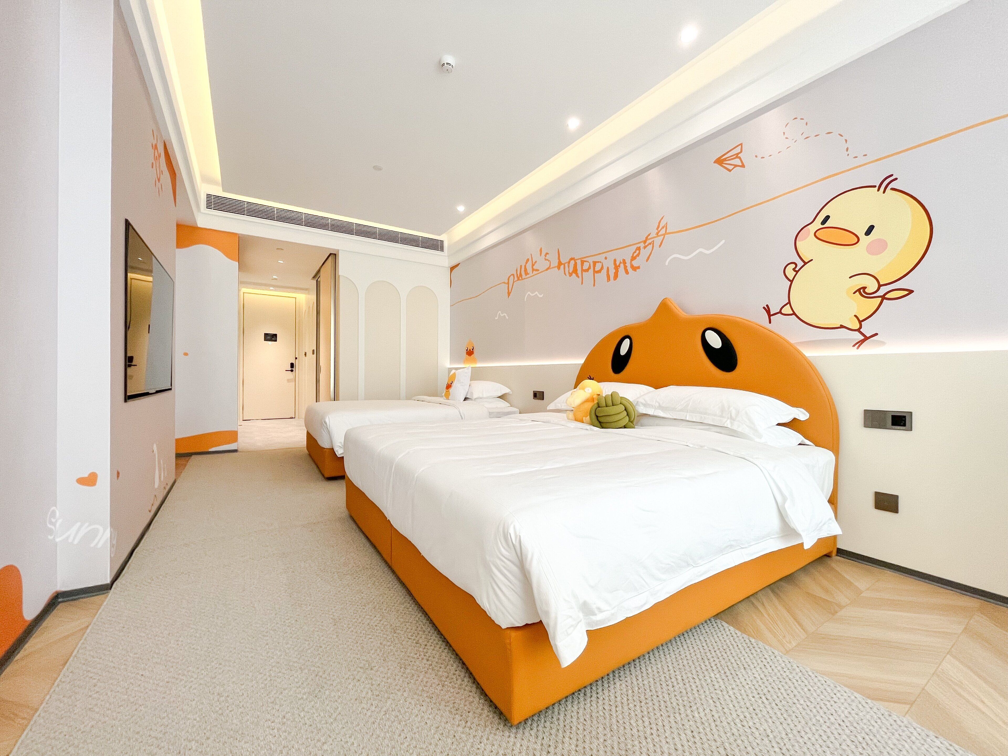 Ein modernes Hotelzimmer mit einem großen Bett, einer Wandmalerei und einer Tür zu einem weiteren Raum.