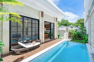 Una casa moderna con piscina, muebles de exterior y un patio.