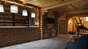 A log cabin interior with a brick fireplace, wooden shelves, and a staircase. - GOLDEN FISH GROUP (Urtasaray)