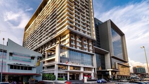 Een modern hotel met meerdere verdiepingen, een opvallende ingang en een grote glazen gevel.