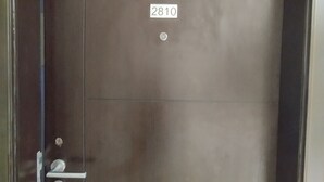 Eine geschlossene Tür mit einer Nummernschild '2810' und einem Schlüsselloch.