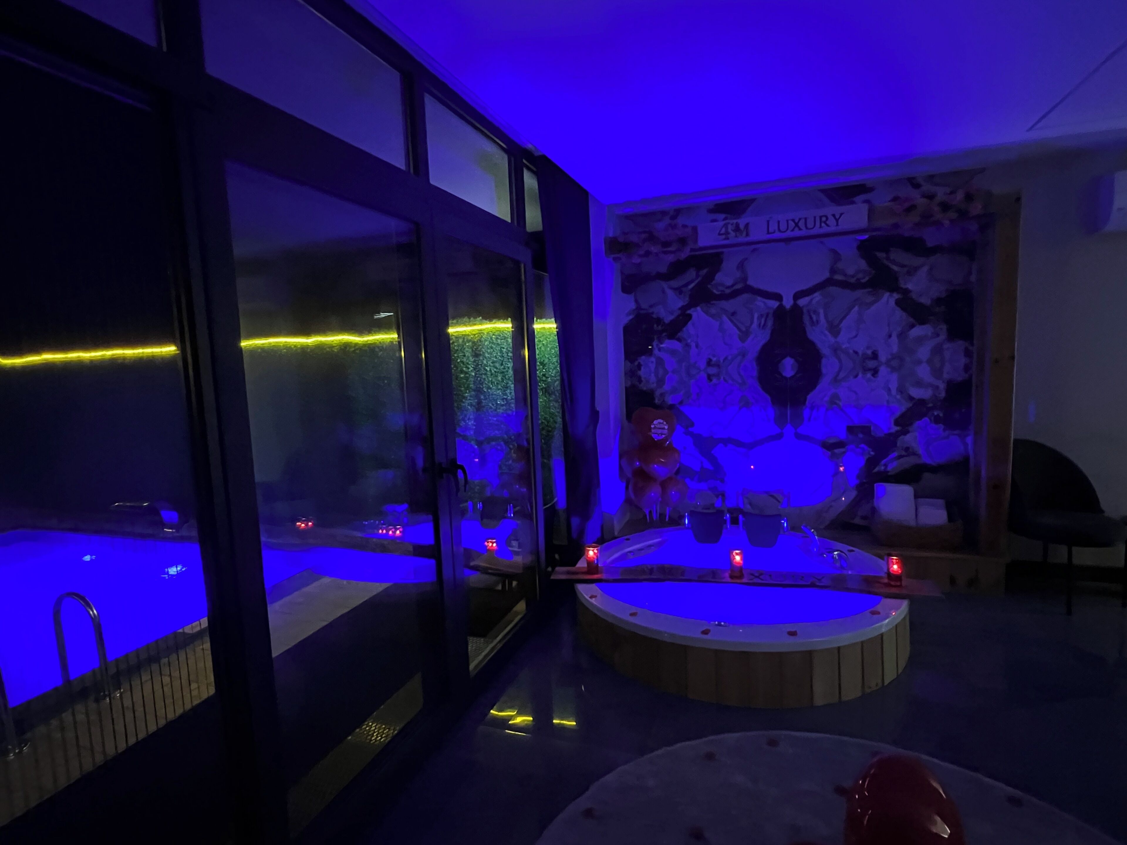 Une salle de spa équipée d’une grande baignoire, d’une plus petite baignoire ronde et d’un coin salon avec un fauteuil.