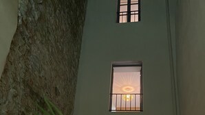 A narrow courtyard with a stone wall on one side and a building with two windows. - By the ramparts, house with pool & stunning view, guesthouse La Trivala (Carcassonne)