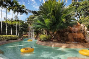 A water park with clear water, palm trees, and a rocky waterfall. - Hyatt Coconut Cove! Lazy River! Quiet Location! Sleeps 8! (Bonita Springs)