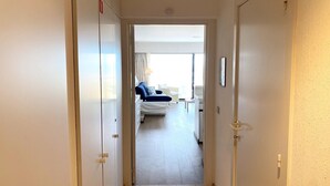 A hotel room with a bed, bedside table, and a view of the outside. - Apartment in Nieuwpoort by the Beach (Nieuwpoort)