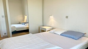 Una camera d'albergo con un letto grande, un comodino e una abat-jour.