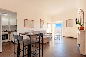 A modern living room with a dining area, a sofa, and a view to the outside. - Sea View Apartment Next To Acquarium (Genoa)