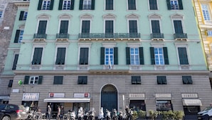 A multi-story building with a central entrance, storefronts on the ground floor, and a row of balconies. - Sea View Apartment Next To Acquarium (Genoa)