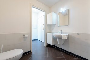 A modern bathroom with a toilet, sink, and mirror. - Sea View Apartment Next To Acquarium (Genoa)