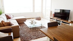 Een moderne woonkamer met een bank, salontafel en tv-meubel.