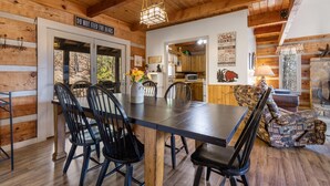 A rustic wooden interior with a dining area, kitchen, and seating area. - Mountain Vintage (Sevierville)