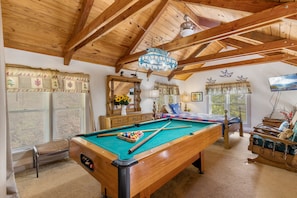 Relax in a warm, inviting space with a pool table, plush seating, and a TV.