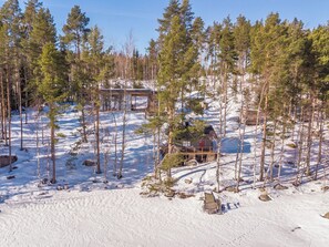A cabin surrounded by a forest with snow-covered ground. - Villa luoto by Interhome (Jyväskylä)