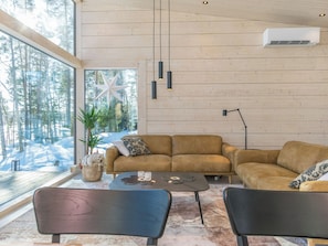 Una sala de estar moderna con un ventanal grande, un sofá, dos sillones, una mesita de centro y una decoración con forma de estrella.
