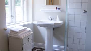 Ein Badezimmer mit Schachbrettboden, einem Waschbecken, einer Toilette und einer Dusche.