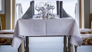 A dining table set for six with a view of a lake. - Ballebro Færgekro (Sønderborg)