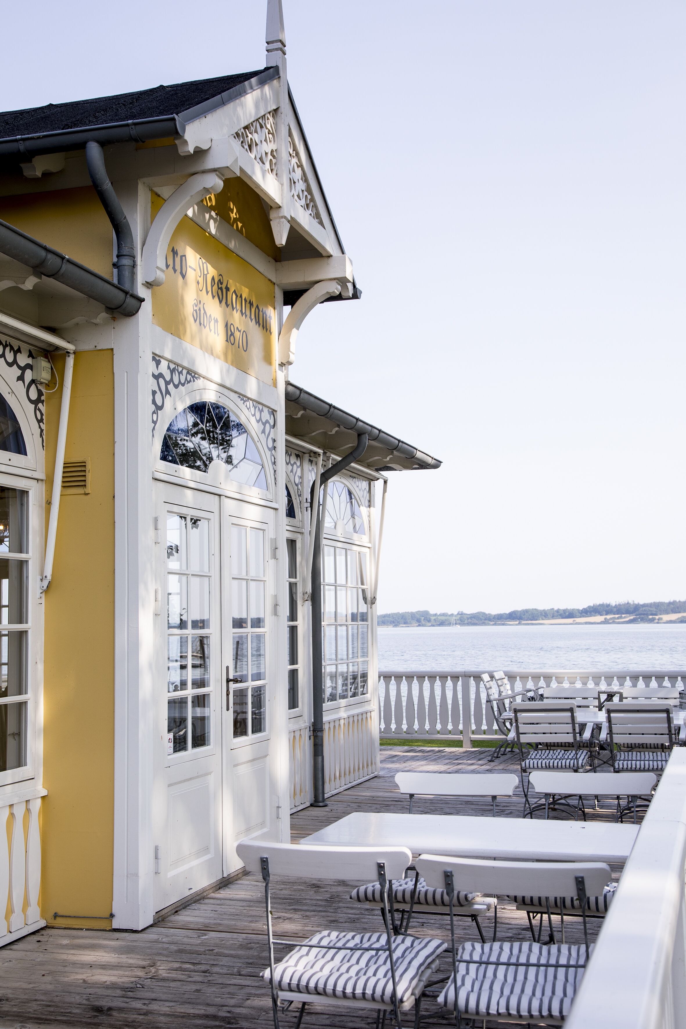 Un restaurante frente al agua con terraza y vistas al mar.