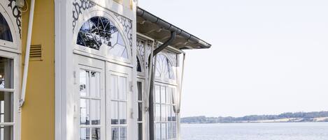 Un restaurante frente al agua con terraza y vistas al mar.