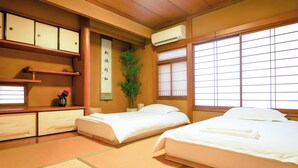 Quarto japonês tradicional com tatame, duas camas, um painel shoji e um pergaminho pendurado.